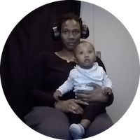 a baby and his mom participate in a habituation study. They both look at a tv screen in a dark room.