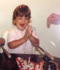 Dr.Bergelson, pictured as a two year old, claps in front of a birthday cake