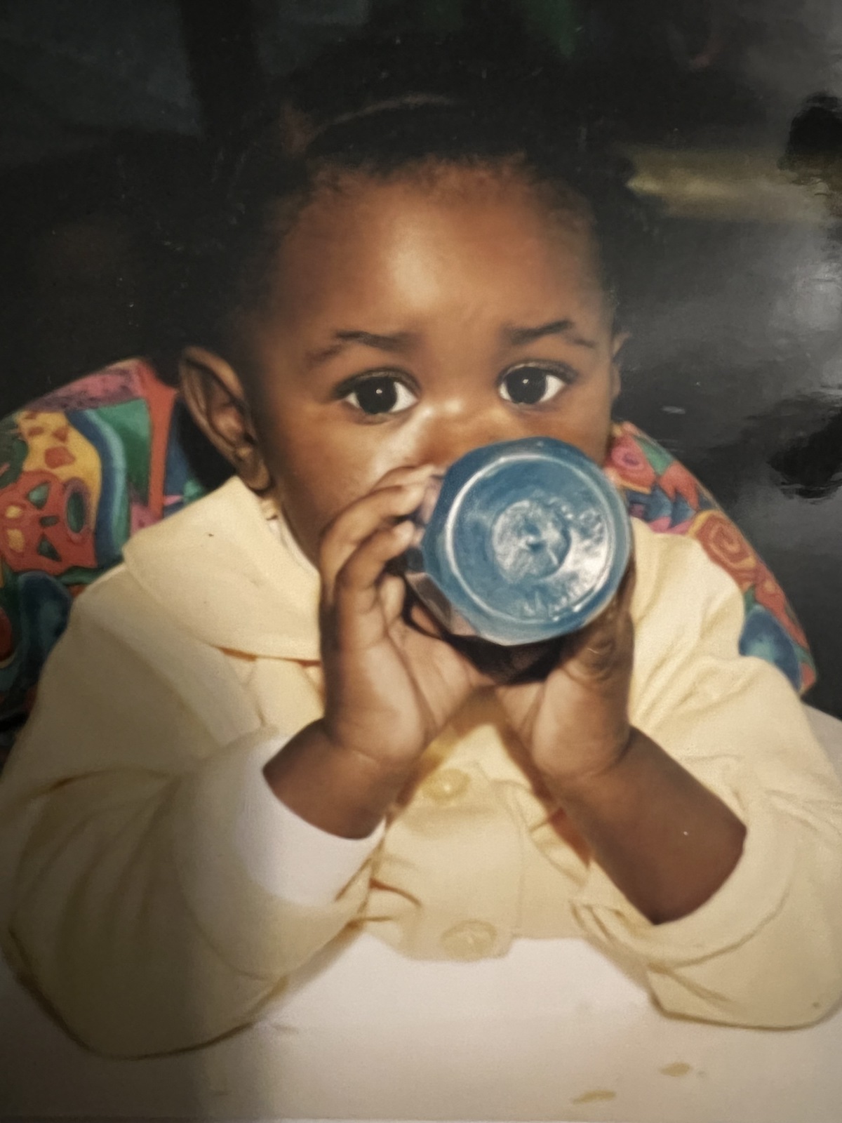 Baby Kristen looks at the camera while drinking from a bottle